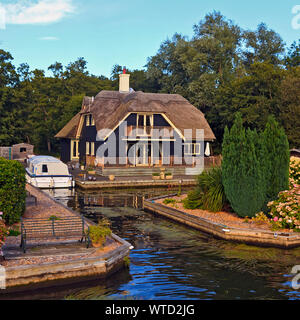 Reetgedeckte Hütte mit Bootsanlegestelle am Ufer des Flusses Bure in der Nähe von Wroxhem auf den Norfolk Broads, England, Großbritannien Stockfoto