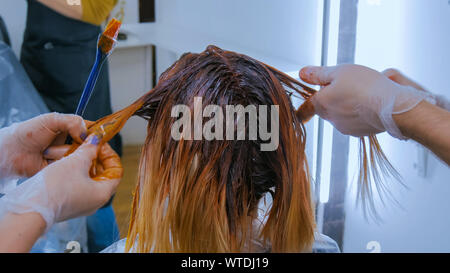 Zwei professionelle Friseure Färbung Haare der Frau Client im Studio Stockfoto