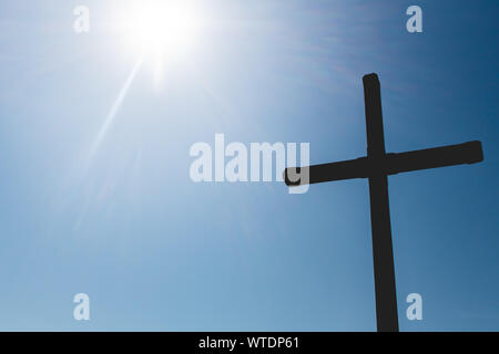 Silhouette Foto von einem Kreuz mit Sun Flair auf der Seite. Stockfoto