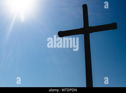 Silhouette Foto von einem Kreuz mit Sun Flair auf der Seite. Stockfoto