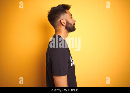 Arabische indischen Hispanic sichern Mann mit Sicherheit gleichmäßig über isolierte gelben Hintergrund auf der Suche nach Side, entspannen Profil mit natürliches Gesicht pose mit Stockfoto