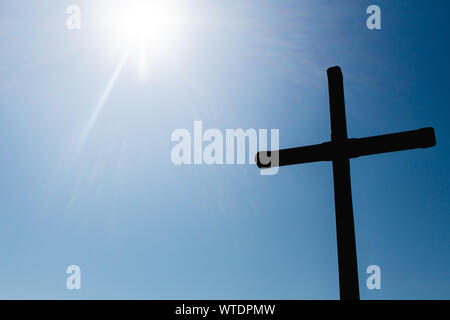 Silhouette Foto von einem Kreuz mit Sun Flair auf der Seite. Stockfoto