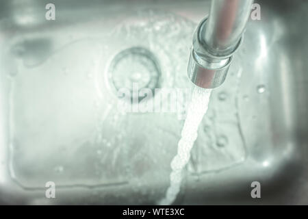 Tippen Sie auf "Öffnen" gießt Wasser in das Waschbecken. Stockfoto