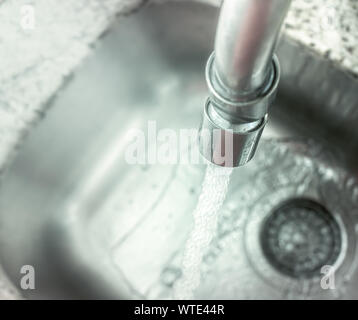 Tippen Sie auf "Öffnen" gießt Wasser in das Waschbecken. Stockfoto