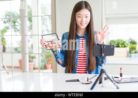 Schöne asiatische Einflussnehmer Frau Aufnahme Make-up Tutorial über Smartphone-kamera tun ok Zeichen mit den Fingern, ausgezeichnete Symbol Stockfoto