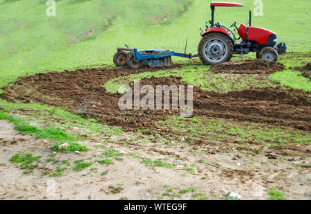 Red landwirtschaftlichen Traktor Anbauflächen in den Bereichen. Selektive konzentrieren. Stockfoto