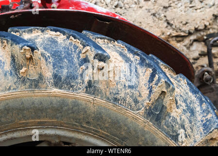 Details Der Rote Traktor Nahaufnahme, Ansicht von unten, schwarz Reifen. Selektive konzentrieren. Stockfoto