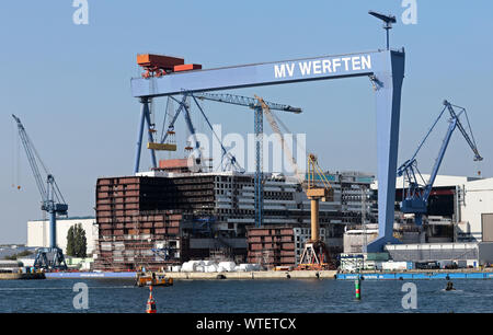 Rostock, Deutschland. 11 Sep, 2019. Im Dock der Warnemünde Werft in MV Werften der 216 Meter langen mittleren Abschnitt der globale Klasse Kreuzfahrtschiff ist im Bau. Das Schiff ist über 342 Meter lang, 54 Meter breit und 60 Meter hoch mit 20 Etagen vom Kiel bis zu den Schornstein zu sein. Wie das Unternehmen mitteilte, ist das größte Kreuzfahrtschiff der Welt. Quelle: Bernd Wüstneck/dpa-Zentralbild/ZB/dpa/Alamy leben Nachrichten Stockfoto