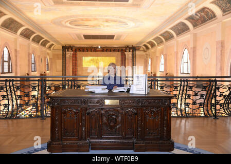 Venedig, Italien. Ehemalige First Lady und US-Außenministerin Hillary Clinton sitzt auf der künstlerischen Installation des amerikanischen Künstlers Kenneth Goldsmith Stockfoto