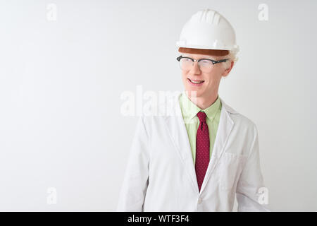 Albino Wissenschaftler Mann mit Brille und Helm stehen über isoliert weißer Hintergrund entfernt, mit einem Lächeln auf dem Gesicht zu Seite, natürlicher Ausdruck. L Stockfoto