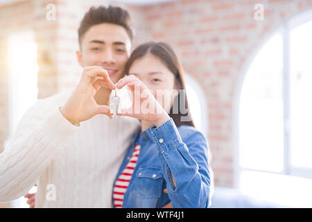Jungen asiatischen Paar hält Schlüssel der neuen Haus und lächelte glücklich und aufgeregt, Umzug in eine neue Wohnung Stockfoto