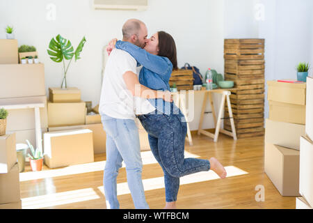 Junges Paar in Liebe umarmen arround carboard Boxen im neuen Zuhause feiern, sehr glücklich Umzug in neue Wohnung Stockfoto