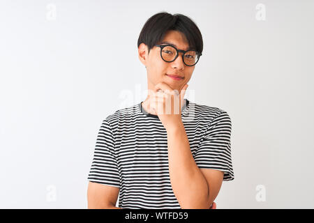 Chinesischer Mann mit Brille und Marine gestreiftes T-Shirt stehend über isoliert weißer Hintergrund mit Blick auf die Kamera sicher lächelnd mit verschränkten Armen Stockfoto