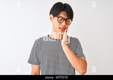 Chinesischer Mann mit Brille und Marine gestreiftes T-Shirt stehend über isoliert weißer Hintergrund berühren den Mund mit der Hand mit schmerzhaften Ausdruck, weil Stockfoto