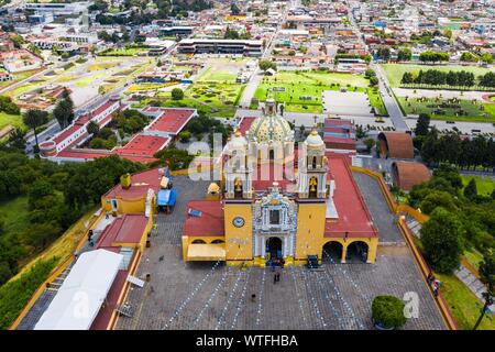 Luftaufnahme des Heiligtums der Virgen de los Remedios in der archäologischen Zone von Cholula, Puebla, Mexiko. Tlachihualtépetl. Puebla hat den mexikanischen Traditionen: Gastronomische, koloniale Architektur und Keramik. Malte talavera Fliesen schmücken den alten Gebäuden. Die Kathedrale von Puebla, im Stil der Renaissance, hat eine hohe Kirchturm mit Blick auf den Zocalo, dem zentralen Platz oder Zócalo. Ich historische. Architektur ist ein UNESCO-Weltkulturerbe. Sehenswürdigkeiten: Kathedrale, Tempel der Gottesmutter von Concord, ehemaligen Carolino College, Palafoxiana Bibliothek, Tempel von Santo Domingo. (© Foto: LuisGutie Stockfoto