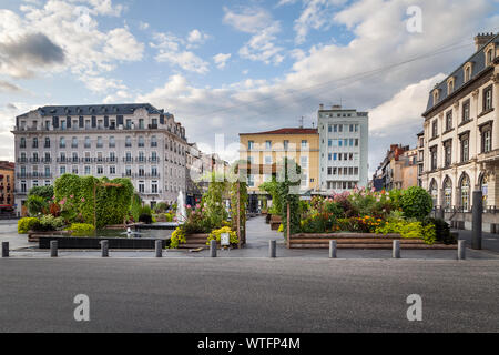 Schöne, bunte natürliche Oase auf dem Place de Jaude Stadtplatz von Clermont Ferrand in Frankreich, traditionelle Architektur und bunten bewölkter Himmel Stockfoto