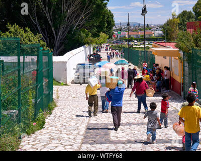 San Andrés Cholula, Mexiko, 30. September 2018 - die Menschen, die arbeiten und die Touristen zu Fuß entlang der Calle 8 Pte Straße, aus dem Heiligtum Unserer Lieben Frau von Abhilfemaßnahmen absteigt. Stockfoto