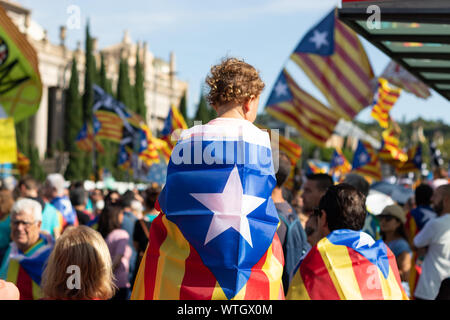 Baby von seinem Vater gehalten und mit katalanischen städtischer Abgeordneter Flagge bedeckt während der Rallye im La Iada, katalanischen Nationalfeiertag. Barcelona, 2019. Stockfoto