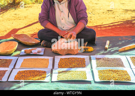 Der Kings Creek Station, Northern Territory, Australien - 21.August 2019: Australian Aboriginal Frau zerquetscht mit einem Stein bush Samen an Karrke Aborigines Stockfoto