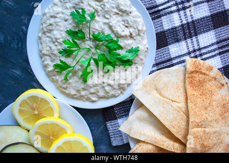 Berühmte traditionelle arabische Küche - dip Baba ganoush mit pita Brot und frische Zitrone. Flach, Ansicht von oben. Baba ganoush. Stockfoto