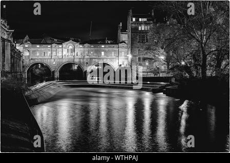 Schwarze und weiße Schuß von Pulteney Bridge und Wehr in Bath, England, bei Nacht Stockfoto