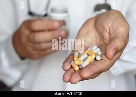 Arzt, Pillen, Arzt bestand in der Handfläche Medikation in Kapseln. Konzept der Dosis von Drogen während der kalten Jahreszeit, Vitamine, medizinische Untersuchung Stockfoto