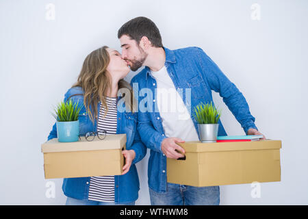 Junge schöne Paar hält Kartons sehr glücklich für ein neues Zuhause auf weißem Hintergrund isoliert Stockfoto