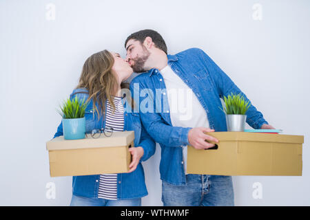 Junge schöne Paar hält Kartons sehr glücklich für ein neues Zuhause auf weißem Hintergrund isoliert Stockfoto