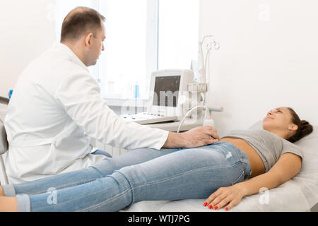 Junge Frau in 4D Ultraschall. Die Ultraschalldiagnostik, die Untersuchung des Abdomens. Stockfoto