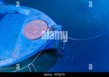 Bug der Griechischen verwittertes kleines Holzboot in Nahaufnahme vor Anker in der Marina. Stock Bild. Stockfoto