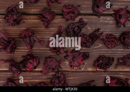 Menge ganz süßen roten kandierten Hibiscus flatlay auf braunem Holz Stockfoto