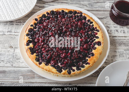 Berry pie mit Kirsche, Johannisbeere, Brombeere, Heidelbeere auf weissem Holztisch. Käsekuchen. Stockfoto