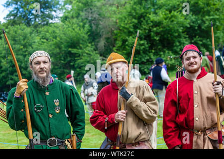 Eine Gruppe von Männern, die in den mittelalterlichen Kostüm mit den Teilnehmern am mittelalterlichen Fayre. Stockfoto