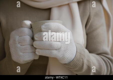 In der Nähe von Frau Hände in weißen Handschuhen holding Becher Stockfoto