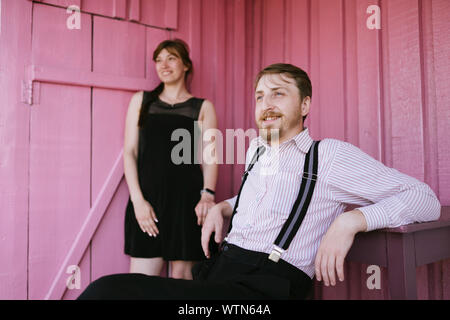 Happy ländlichen Paar auf rosa Wand Hintergrund Stockfoto