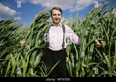 Gerne Landwirt Kerl in Mais stehend Stockfoto