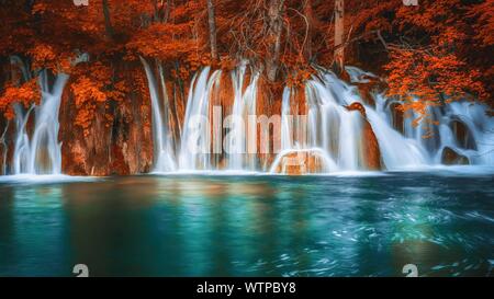 Eine lange Belichtung eines wunderschönen Wasserfällen und Wasser Pool in einem Wald, mit baum laub und Vegetation in Fantasy Herbst Farben von VIBR Stockfoto