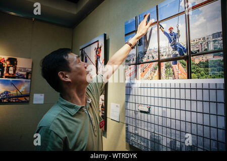 (190912)-BEIJING, Sept. 12, 2019 (Xinhua) - Der Fotograf stellt seine Arbeit während einer Fotoausstellung zum 70. Jahrestag der Befreiung der Shanghai zu markieren, im Osten Chinas Shanghai, Sept. 11, 2019. (Foto von Wang Xiang/Xinhua) Stockfoto