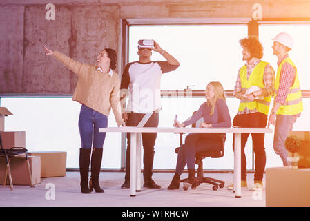 Jungen multiethnischen Business Team Dokumente prüfen und Business Workflow auf der Baustelle unter Verwendung der Virtual reality Headset und Laptop wi Stockfoto