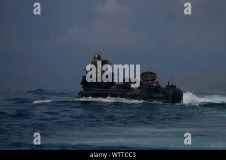 Ein Angriff Amphibienfahrzeug mit Fox Company, Bataillon Landung Team, 2.BATAILLON, 1 Marines, 31 Marine Expeditionary Unit, durchquert das Surfen während eines simulierten Mechanisierte amphibischen Raid im Camp Schwab, Okinawa, Japan, August 18, 2019. Die 31. MEU und amphibische Squadron 11, an Bord der Wasp Amphibious Ready Gruppe Schiffe, führte eine Reihe von sequentiellen Operationen, die simulierten naval Expeditionary kombiniert - arme Manöver von Amphibischen Vermögenswerte zum Ufer, wobei Marine Air-Ground Task Force Fähigkeiten über alle warfighting Domänen integriert. (Offizielle Marine Corps Foto von LCpl Kyle Stockfoto