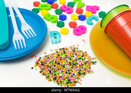 Kunststoffgranulat Einmalgeschirr und Kinderspielzeug aus Polyethylen, Polypropylen, PET-Polymeren Material auf einem weißen Hintergrund. BPA-frei Stockfoto
