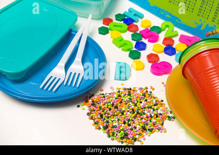 Kunststoffgranulat Einmalgeschirr und Kinderspielzeug aus Polyethylen, Polypropylen, PET-Polymeren Material auf einem weißen Hintergrund. BPA-frei Stockfoto