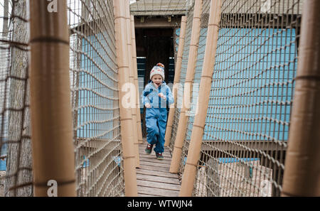 Junge außerhalb auf einem Holz- Spielbereich Stockfoto