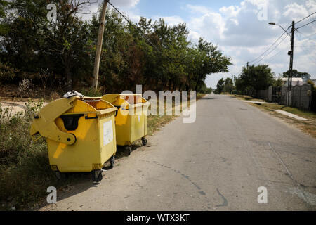 Gelb Kunststoff Müllcontainer auf einem Dorf Straße mit niemand um in ländlichen Rumänien Stockfoto