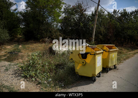 Gelb Kunststoff Müllcontainer auf einem Dorf Straße mit niemand um in ländlichen Rumänien Stockfoto