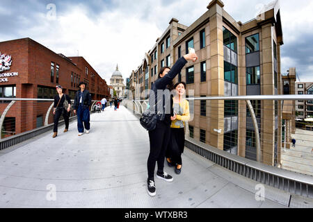 London, England, UK. Japanische Touristen eine selfie auf die Millennium Bridge Stockfoto