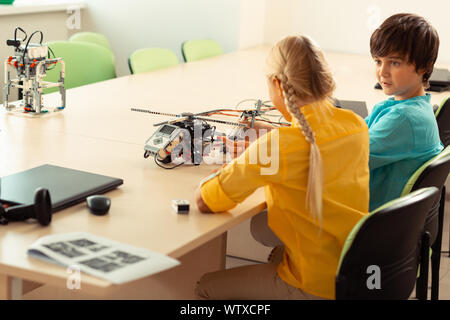 Überrascht Junge an seinem Mitschüler erklärt ihm, ihr Projekt suchen. Stockfoto