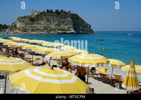 Öffentlichen Strand von Tropea, Kalabrien, Italien. Blick von Norden im August 2019, mit der Hill mit der Kirche von Santa Maria aus Island, an der Rückseite Stockfoto