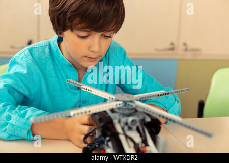 Ernsthafte Schüler arbeiten an seinen Hubschrauber Modell. Stockfoto