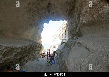 Der Blick aus dem Inneren einer natürlichen Höhle in Tropea, Kalabrien, Italien im August 2019 mit einem Strand an der Rückseite Stockfoto